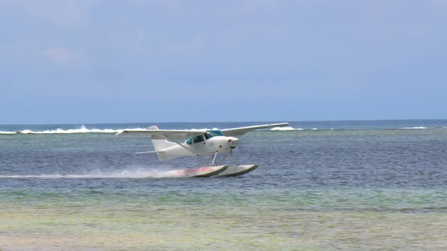 White sea plane landing in a calm lagoon