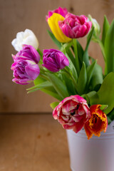 Mix of spring tulips flowers. Bouquet in a vase. Multi-colored spring flower. Gift. Red, pink, white and yellow. Background with flowers tulips close-up different colors.