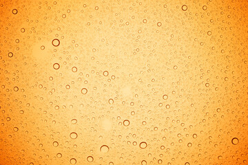 Rain droplets on yellow glass background, Water drops on yellow glass.