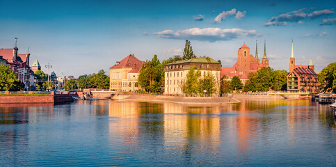 Fototapeta na wymiar Bright summer cityscape of Wroclaw, Poland, Europe. Beautiful morning view of Tumski island with cathedral of St. John on Odra river. Traveling concept background.