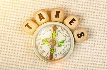 On the table is a compass and cubes with the inscription - TAXES