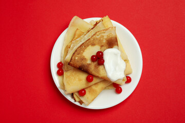 Concept of tasty food with crepes on red background