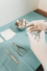 Chiropodist preparing tools for surgery in the medical center with protective gloves