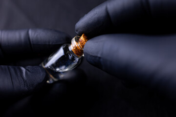 in the hands of the master is a bottle of argan oil for application to the eyebrows