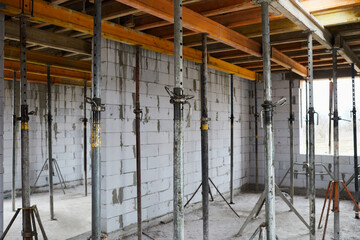 The supports of monolithic floor formwork at a construction site. Telescopic props for concrete flooring. Construction of a modern apartment building  - obrazy, fototapety, plakaty