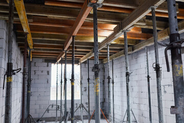 The supports of monolithic floor formwork at a construction site. Telescopic props for concrete...