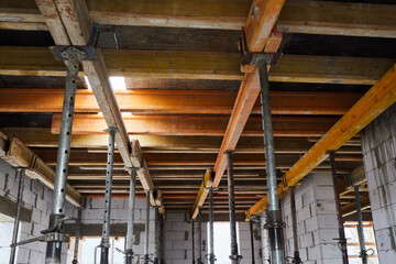 The supports of monolithic floor formwork at a construction site. Telescopic props for concrete...