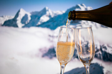 champagne glasses  and snowy peaks in background  New Year