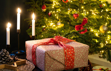 Fototapeta na wymiar Gift box near a Christmas tree in a cozy home close-up