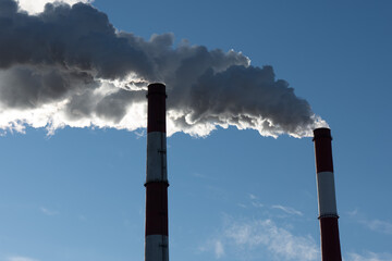 Two pipes from which there is smoke that pollutes the environment.
