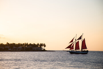 Fototapeta premium Sailboat crossing the horizon in the late evening