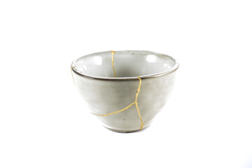 kintsugi gold cracks restoration, Japanese bowl fixed with the antique kintsukuroi restoration technique, the beauty of imperfections, representation of a trauma