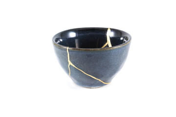 kintsugi gold cracks restoration, Japanese black bowl fixed with the antique kintsukuroi...