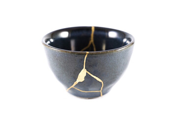 kintsugi gold cracks restoration, Japanese black bowl fixed with the antique kintsukuroi...