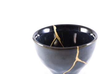 kintsugi gold cracks restoration, Japanese black bowl fixed with the antique kintsukuroi...