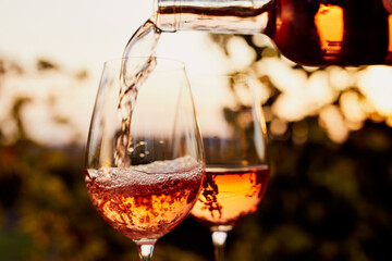 Pouring rosé wine into glasses outdoors at a garden party