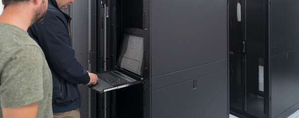  Technicians team updating hardware inspecting system performance in super computer server room or...