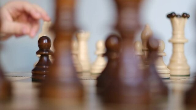 chessboard rotates in a circle. slow motion video. children's hand puts a chess piece on the chess table. Business Solutions, Success Strategy.