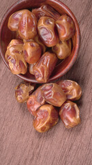 Dates in wooden bowl on background. dried dates fruit.