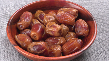 Dates in wooden bowl on background. dried dates fruit.