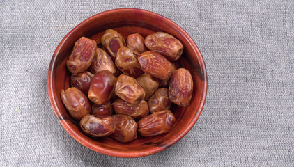 Dates in wooden bowl on background. dried dates fruit.