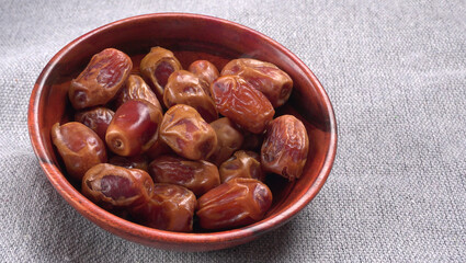 Dates in wooden bowl on background. dried dates fruit.
