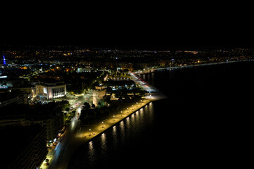 Fototapeta na wymiar Night aerial view of Thessaloniki promenade with white tower in the foreground.