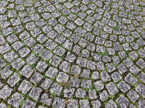 Cobbled stone background laid on a pathway with a rough circular brick texture pattern, stock photo image picture