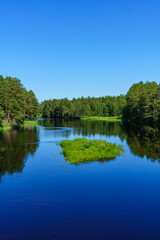 Fototapeta na wymiar Beautiful blue river flowing through a lush green landscape