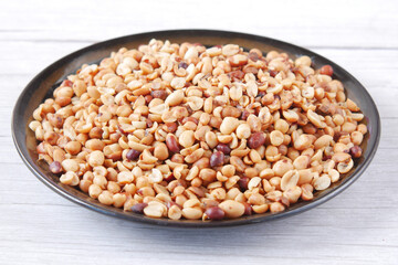 Processed pea nuts in a bowl on table top down .