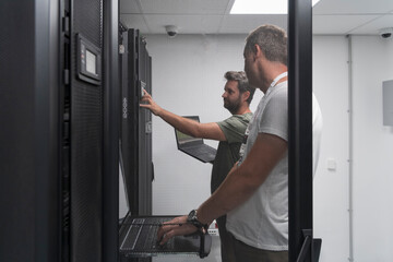 Fototapeta na wymiar Technicians team updating hardware inspecting system performance in super computer server room or cryptocurrency mining farm.