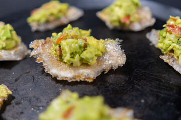 Pork rinds with guacamole on traditional Mexican comal