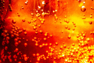 macro cola,Detail of Cold Bubbly Carbonated Soft Drink with Ice,Close up view of the ice cubes in dark cola background. Texture of cooling sweet summer's drink with foam and macro bubbles on the glass