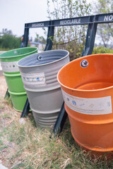 Fototapeta premium Spanish signs above colorful trash cans in park
