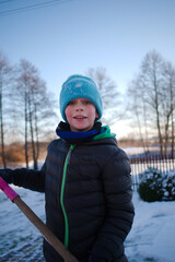 Fototapeta młody chłopak trzyma w dłoniach szuflę do śniegu  obraz