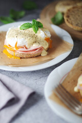 Egg benedict sandwiches - muffin with poached egg, ham and hollandaise sauce