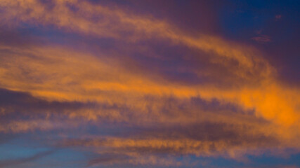 Ciel rougeoyant pendant le coucher du soleil, sous des nuages de haute altitude