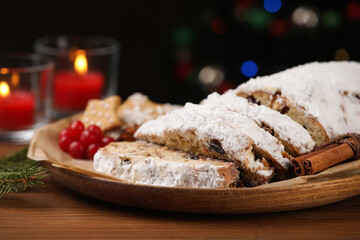 Traditional Christmas Stollen with icing sugar on wooden table, closeup