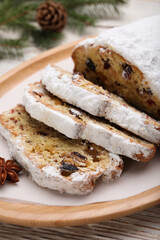 Traditional Christmas Stollen with icing sugar on white wooden table, closeup