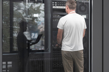  Technicians team updating hardware inspecting system performance in super computer server room or cryptocurrency mining farm.