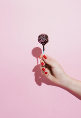 Sweet chocolate Lollipop candy on pink creative abstract background. Love concept.