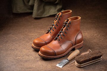 Handcrafted brown leather shoes with cobbler tools on the backgound