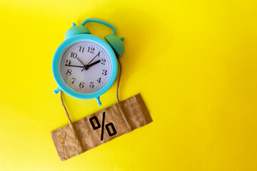 Interest rate percent icon on a yellow background with a clock. Financial and mortgage interest rates concept.