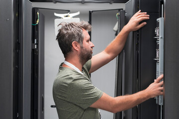 Fototapeta na wymiar IT engineer working In the server room or data center The technician puts in a rack a new server of corporate business mainframe supercomputer or cryptocurrency mining farm. 