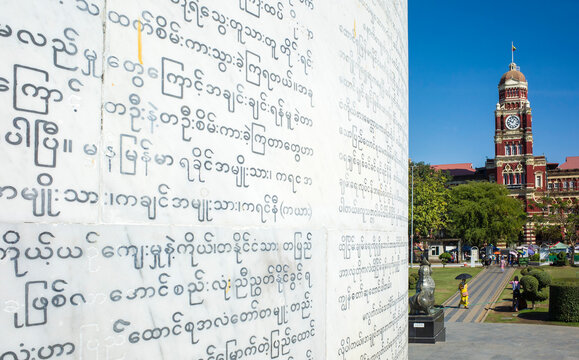 Yangon, Myanmar - December 22, 2019: Independence Monument text close up in Mahabandula Park with view of Yangon Regional High Court clock tower