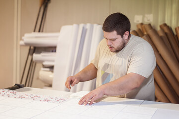 Logistic printing technician worker controls and arranges the printed material