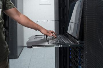 Close up on Data Center Engineer hands Using keyboard on a supercomputer Server Room Specialist...