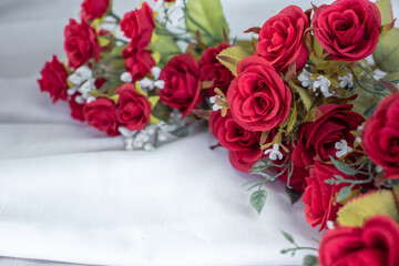 Romantic still life, Red roses on a silk white putty background. Fragrant red flowers, gift concept...