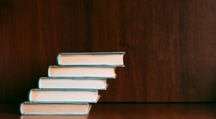 Bookshelf with books stack of lying books. Literary background with copy space for ad text	
