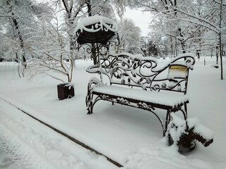 A snow-covered bench with a fairy-tale character